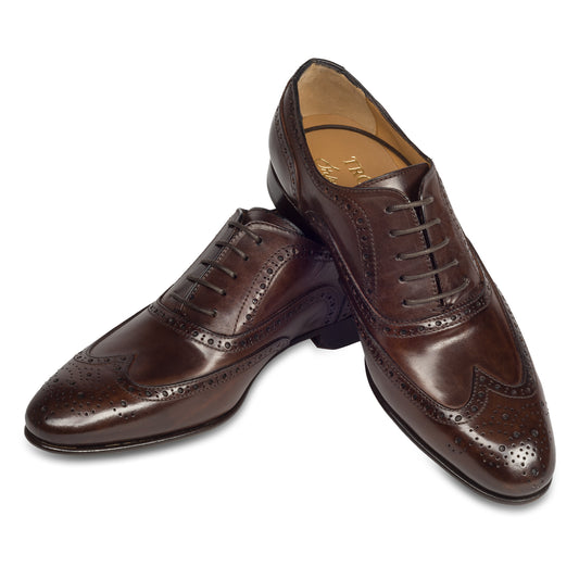 Branchini - Italienische Herren Anzugschuhe Full-Brogue Derby im Budapester-Stil, braun. Aus Kalbsleder handgefertigt und durchgenäht. Paarweise Ansicht Schuhe überkreuzt aufgestellt.