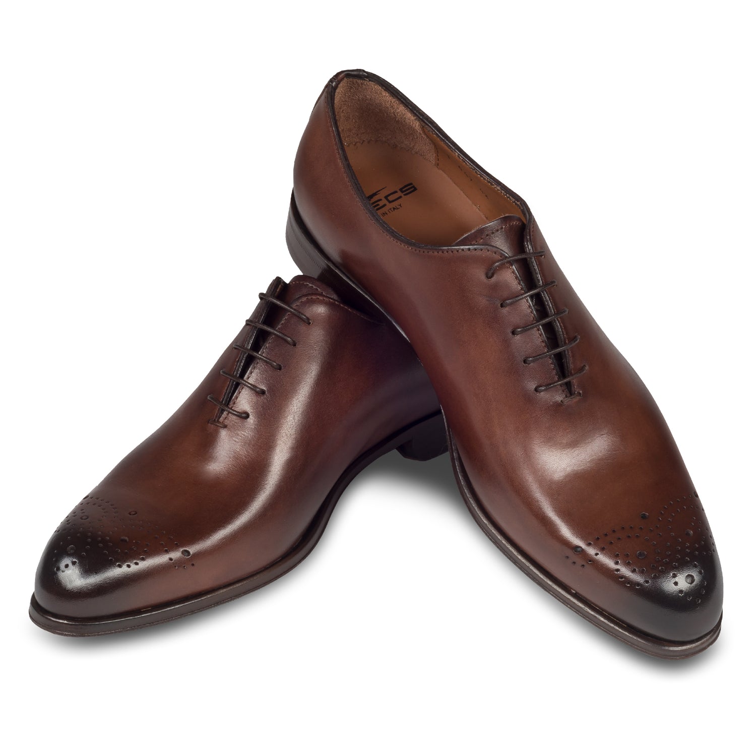 Anzugschuhe von FLECS, Onecut / Wholecut Brogue Schnürer in rotbraun/nußbraun, Durchgenäht. Paarweise Ansicht Schuhe überkreuzt aufgestellt. Bei Sisento.
